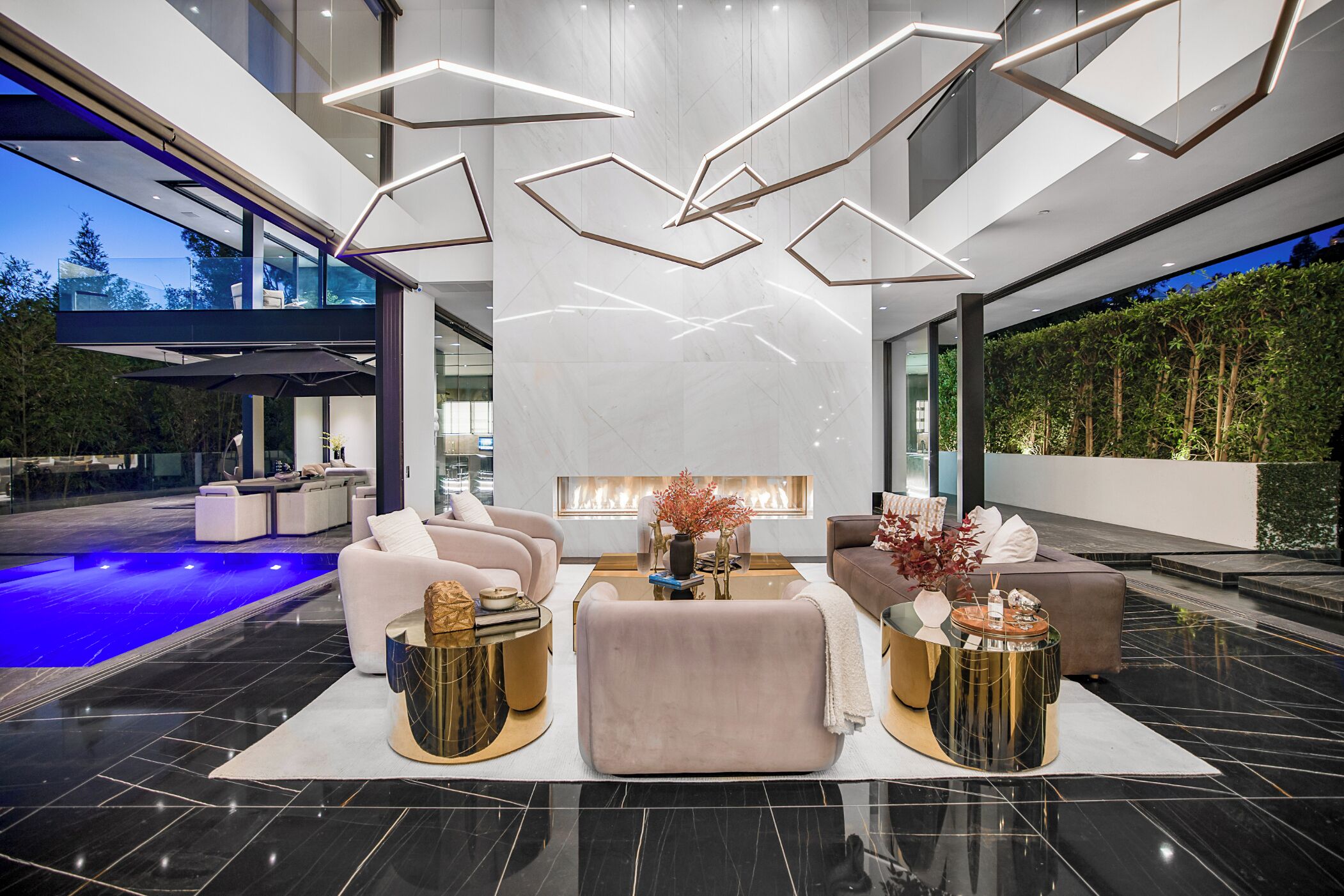 A modern interior with a pool, seating area, and a fireplace.