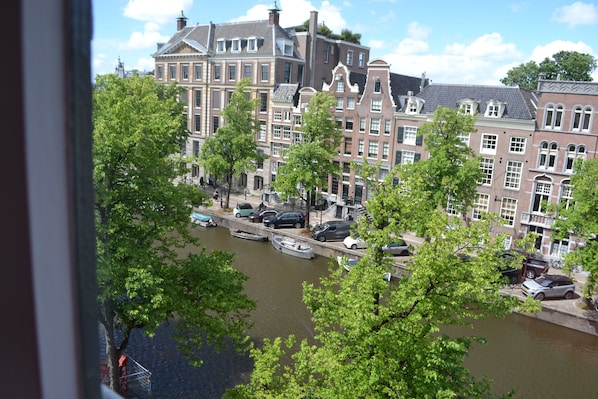 Un canal con barcos, edificios históricos y árboles.