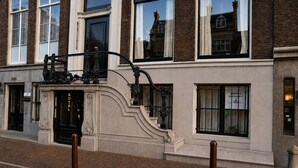 A historic building with a black entrance door, a staircase leading to the entrance, and a sign indicating it is a hotel. - Hotel Keizershof (Amsterdam)