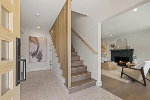 A modern interior with a staircase, a fireplace, and a living area. - The Dona Modern (Studio City)