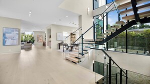 Un interior espacioso con una escalera moderna, un comedor y una sala de estar.