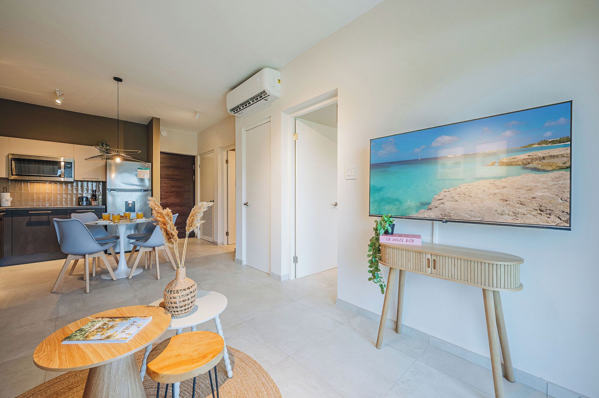 A modern kitchen with a microwave, refrigerator, and dining area with chairs and a table.