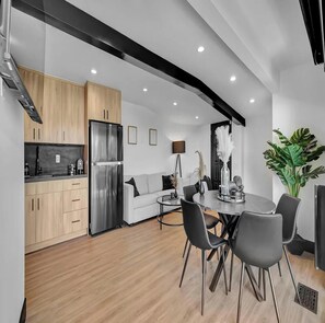 A modern kitchen with wooden cabinets and a stainless steel refrigerator. - Skyview Estate (West Hollywood)