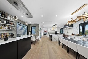 Cozinha moderna com ilha central, espaço bar e área de refeições.