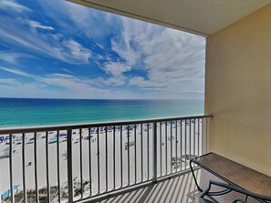 Un balcon avec vue sur une plage et l’océan.