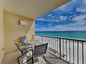 Ein Balkon mit Blick auf Strand und Meer.