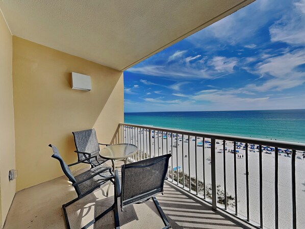 Un balcon avec vue sur une plage et l’océan.