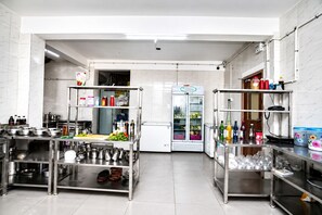 A modern kitchen with stainless steel appliances, a refrigerator, and various kitchen utensils.