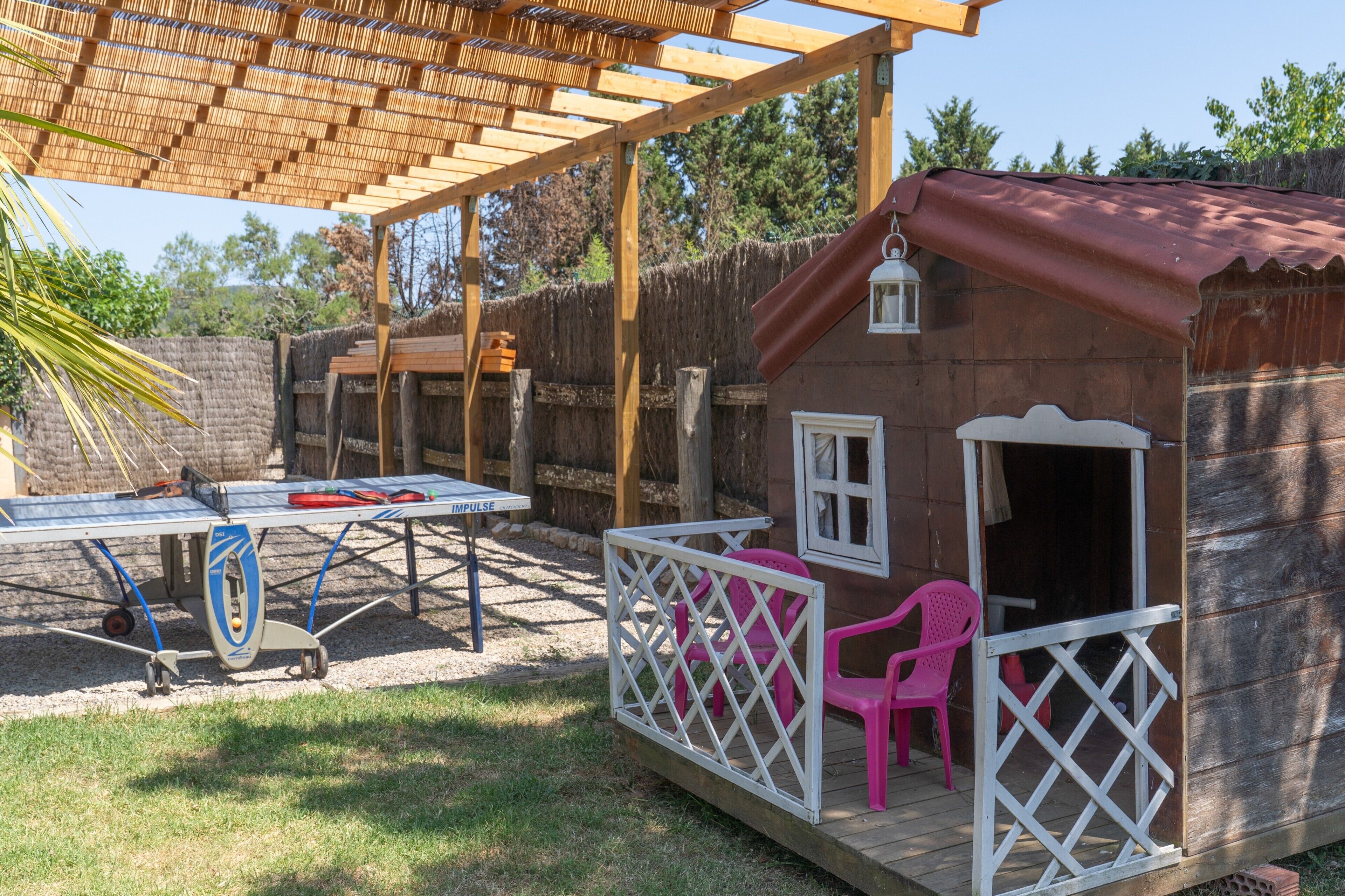 Une cabane en bois avec une véranda, une table et des chaises.