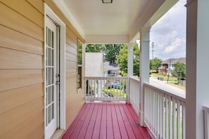 A wooden porch with a red floor, white railings, and a view of a residential street. - 3 Mi to Mercedes-benz Stadium! Group Getaway (Austin)