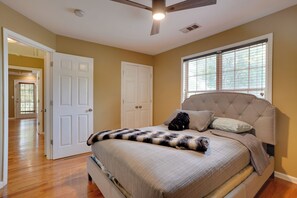 A bedroom with a bed, a ceiling fan, a window with blinds, and a door leading to another room. - 3 Mi to Mercedes-benz Stadium! Group Getaway (Austin)