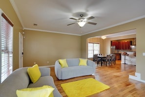A spacious living room with a grey sofa, yellow cushions, and a yellow rug. - 3 Mi to Mercedes-benz Stadium! Group Getaway (Austin)