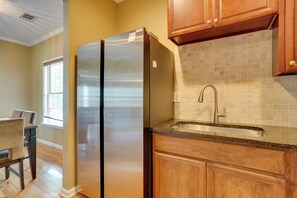 A kitchen with wooden cabinets, a stainless steel refrigerator, a sink, and a window with blinds. - 3 Mi to Mercedes-benz Stadium! Group Getaway (Austin)