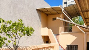 Eine Dachterrasse mit Baum, Blumentopf und Treppe.