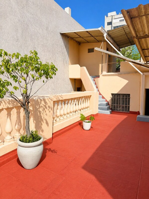 A rooftop with a tree, a potted plant, and a staircase. - Hotel Histórico San Telmo (Buenos Aires)