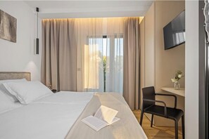 Een hotelkamer met een bed, een bureau, een stoel en een televisie.