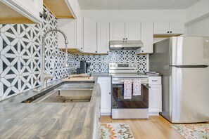 A modern kitchen with white cabinets, a stainless steel refrigerator, a built-in oven, and a patterned backsplash. - 1 Mi to Dtwn Dayton: Unique 3-unit Base! (Dayton)