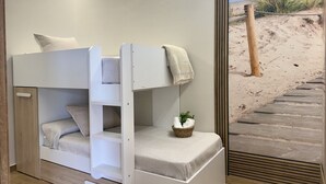 A bunk bed with a view of the beach through a window.