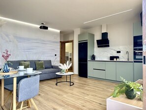 A modern living room with a sofa, coffee table, and dining area. - Flower Beach Helgueras 4 - 6094 (Noja)