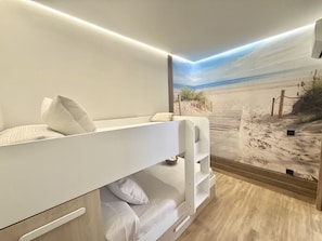 A bunk bed with a view of a beach mural, a small shelf, and a wooden floor. - Flower Beach Helgueras 4 - 6094 (Noja)