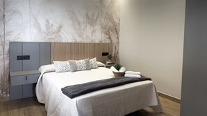 A modern bedroom with a bed, bedside tables, and a wall-mounted TV.