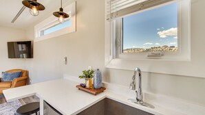 A kitchen with a large window, a sink, and pendant lights. - Mtn Views & Trail Access! 2-unit Cedar City Escape (Cedar City)