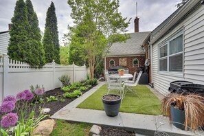 A backyard with a lawn, potted plants, a patio table, and a white fence. - Retreat w/ Yard Near NYC & Metlife Stadium! (Teaneck)