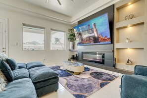 A modern living room with a flat-screen TV, a fireplace, and a large window. - EP Oasis w/ Pool & Spa, Near I-10 & Hospitals (El Paso)