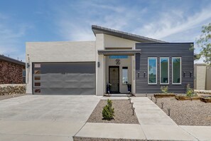 A modern two-story house with a garage, a small front yard with a decorative plant, and a clear sky. - EP Oasis w/ Pool & Spa, Near I-10 & Hospitals (El Paso)