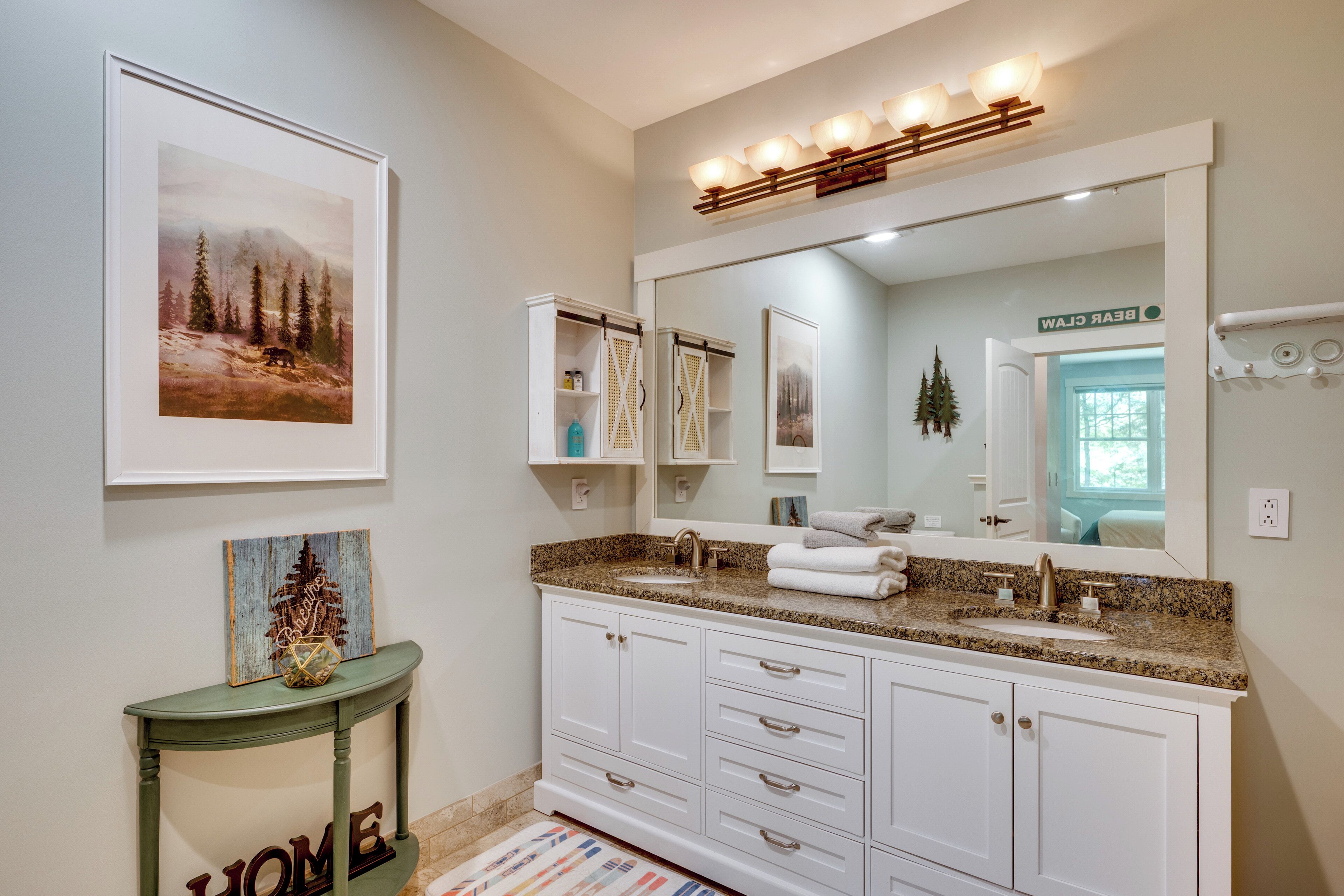 Une salle de bain avec un grand miroir, un lavabo et un meuble-lavabo doté de tiroirs.