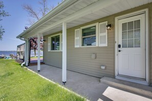A house with a covered porch, a door, and windows. - Lakefront Family Home w/ Dock & Views in Cecil! (Cecil)