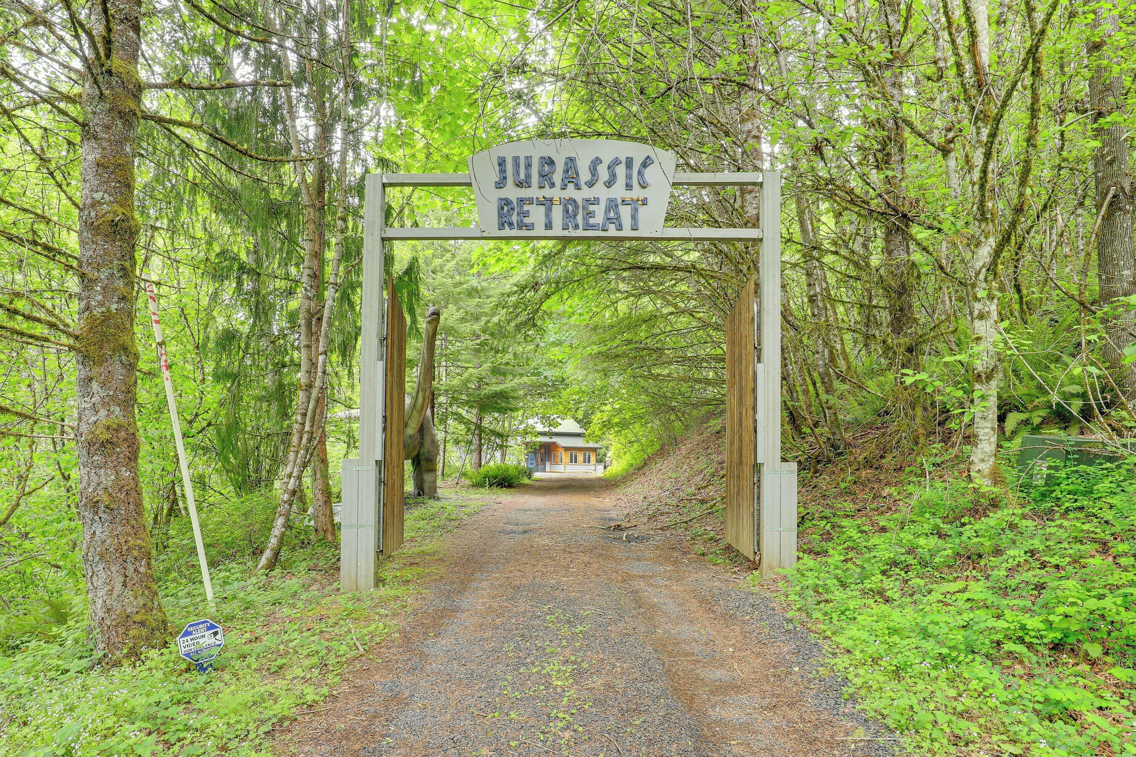 A pathway leading to a building labeled 'Jurassic Retreat' surrounded by dense forest.