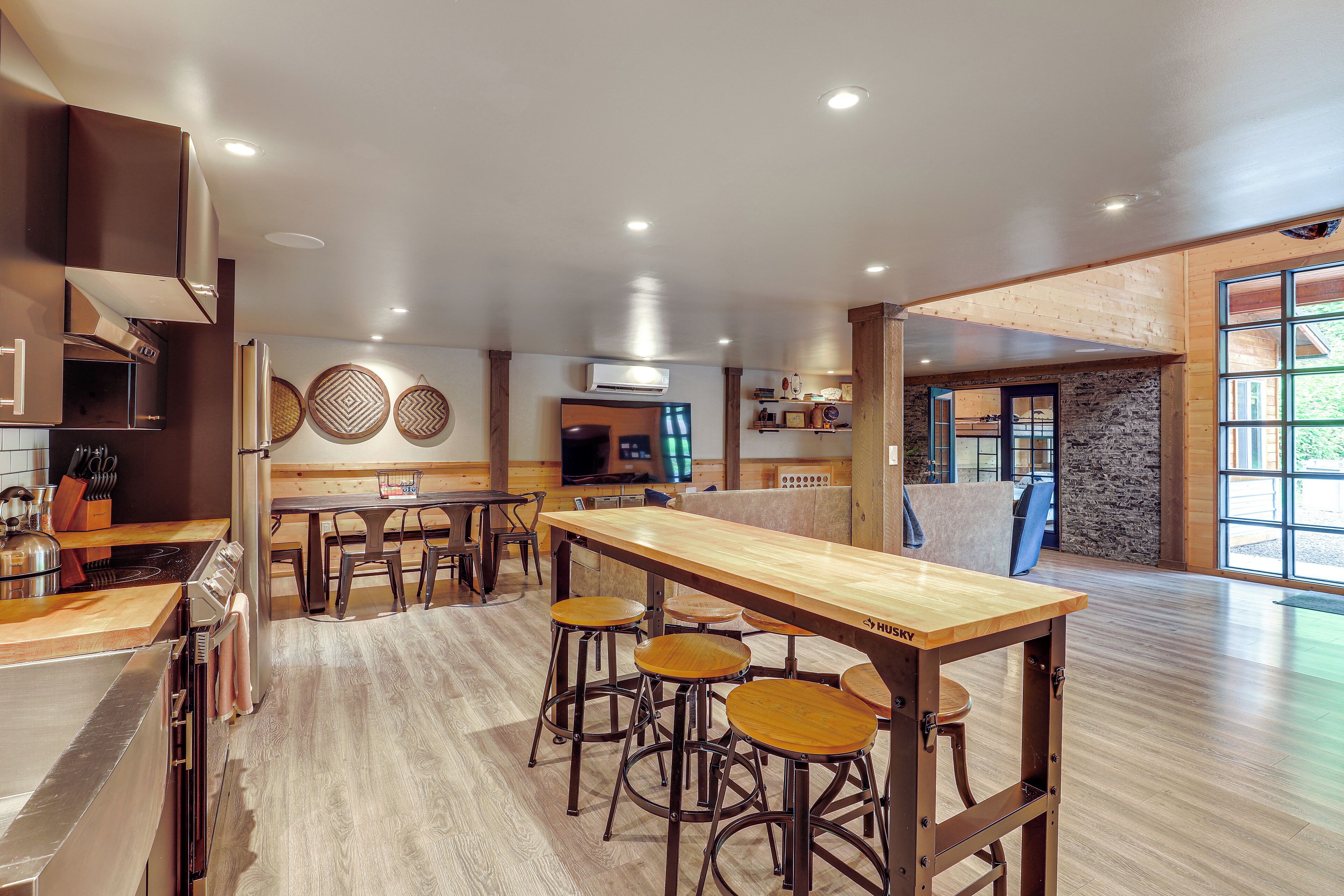 Een moderne keuken met een houten bar, een stenen muur en een groot raam.