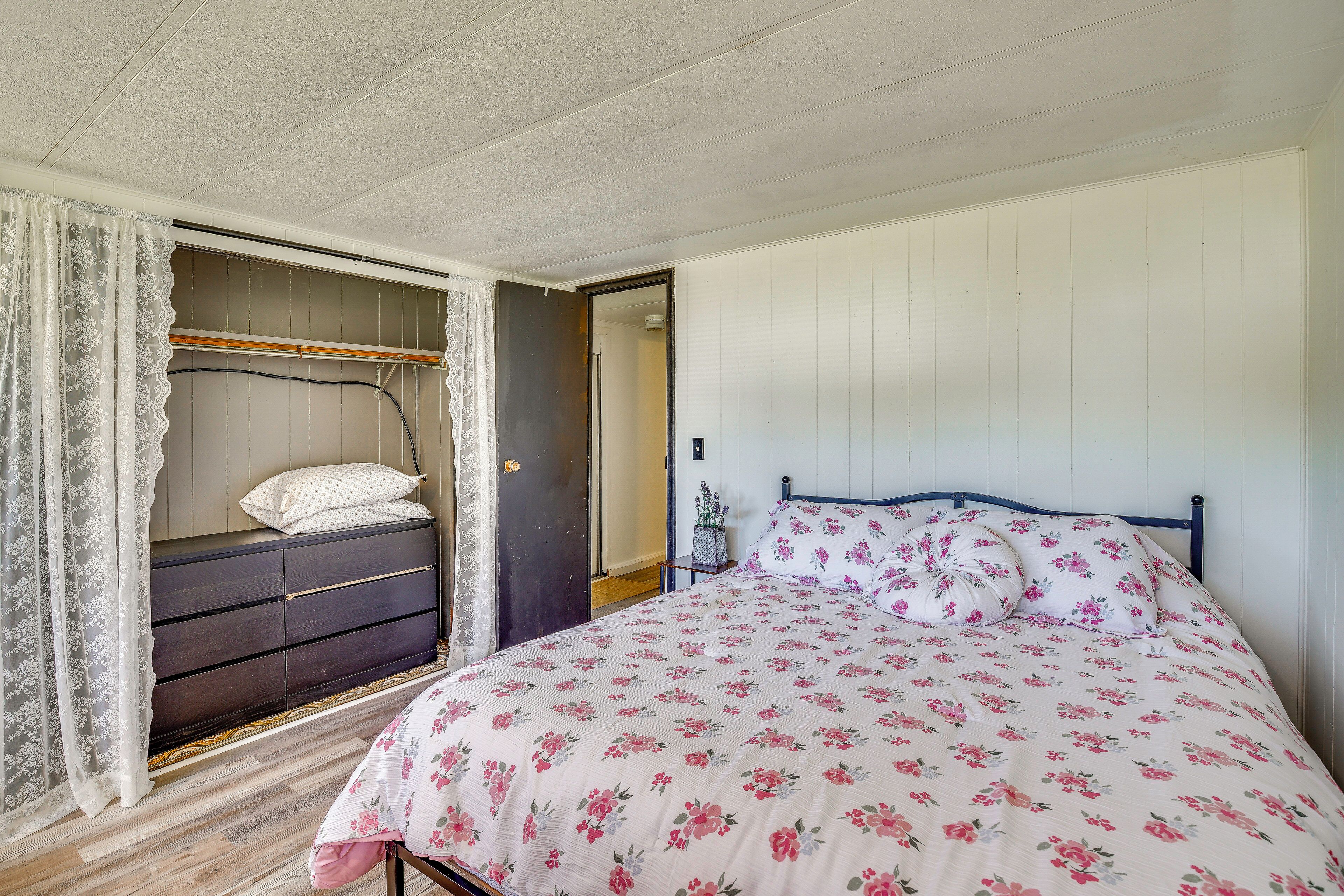 Un dormitorio con cama, armario y puerta que da a otra habitación.