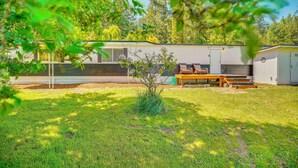 A mobile home with a patio area, a small garden, and a wooden table. - Stunning View! Peaceful Family Home w/ Yard in Roy (Roy)