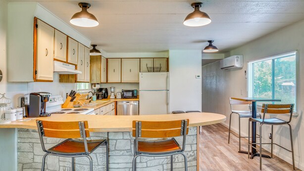 A kitchen with a bar area, wooden chairs, and a window. - Stunning View! Peaceful Family Home w/ Yard in Roy (Roy)