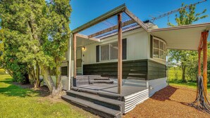 A single-story house with a covered porch, a small deck, and a visible chimney. - Stunning View! Peaceful Family Home w/ Yard in Roy (Roy)