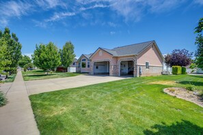A residential house with a driveway, lawn, and trees. - Office, Fire Pit, Deck! Large Rental Near Hill AFB (Clearfield)