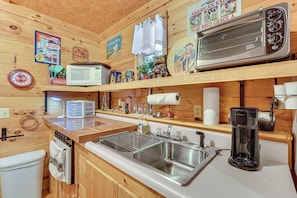 A compact kitchen with a microwave, toaster, sink, and coffee maker. - Smoky Mtn Tiny Cabin Hideaway: Hot Tub, Patio (Englewood)