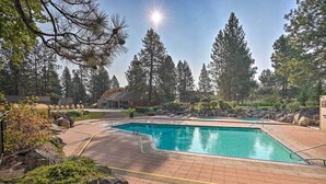 A swimming pool surrounded by rocks and trees, with a clear sky and a sun shining. - Resort Pool & Trails! Cozy Seventh Mountain Condo (Bend)