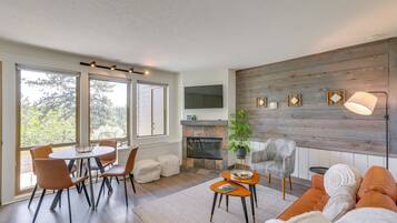 Una sala de estar moderna con chimenea, comedor y sofá.