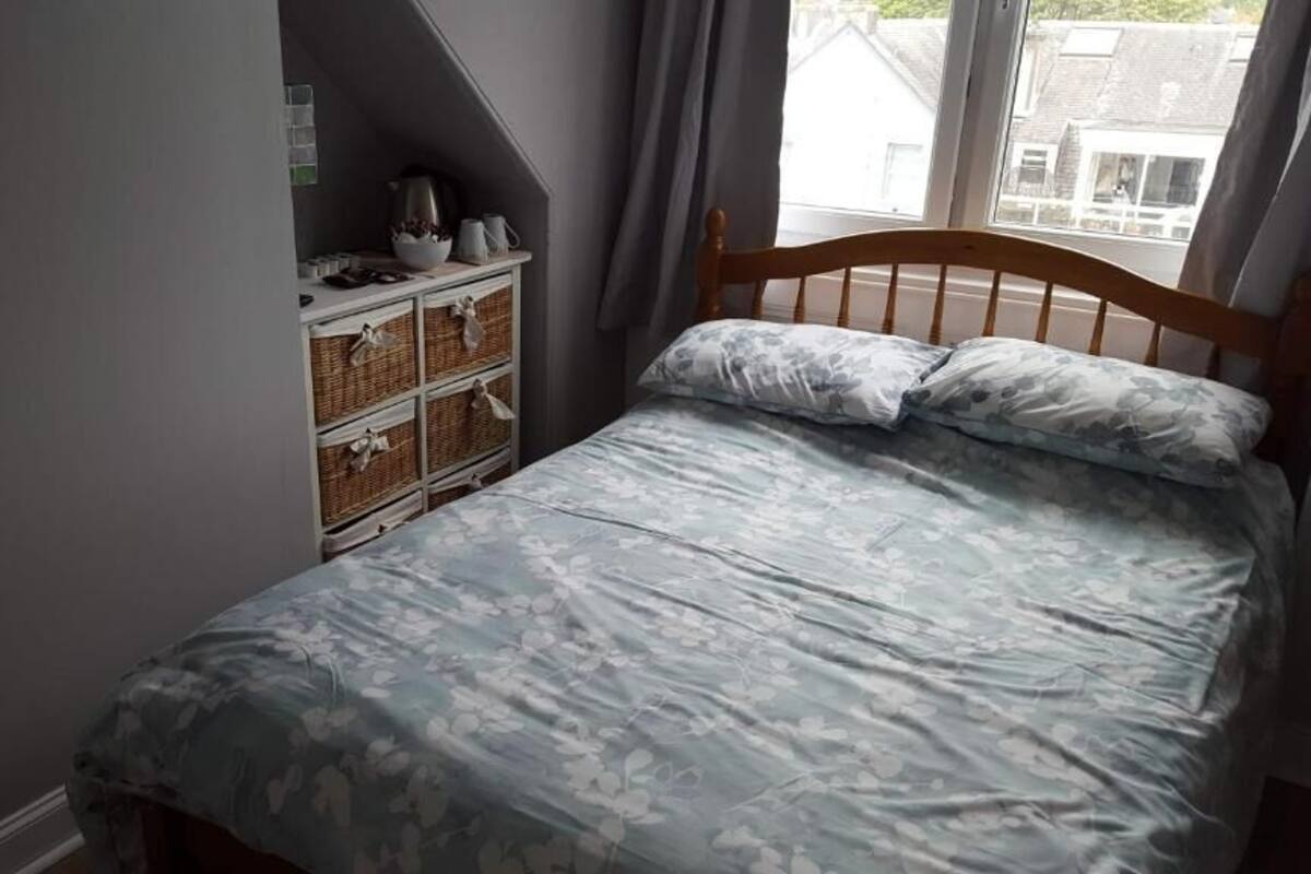 Un dormitorio con una cama, un tocador y una ventana.