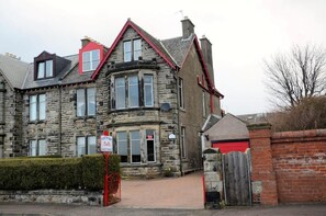 Ein Steinhaus mit rotem Dach, einem Schild, das auf ein Pub hinweist, und einem verschlossenen Eingang.