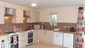 A modern kitchen with a stove, microwave, oven, and dishwasher. - Ballyvoy Camping Barn (Ballycastle)