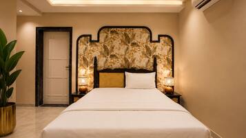 A bedroom with a bed, a ceiling fan, an air conditioner, a door, and a potted plant.