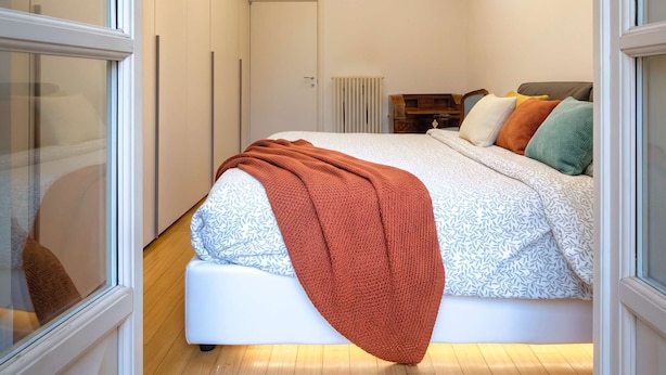 A modern bedroom with a bed, a radiator, and a window. - Casa Paravia - History Meets Contemporary Comfort (Turin)
