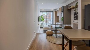A modern interior with a dining area, a large window, and a view of buildings outside. - NOK Modern 1BR Near Usaquen Unicentro (Bogotá)