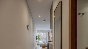A modern interior with a hallway leading to a balcony with a city view. - NOK Modern 1BR Near Usaquen Unicentro (Bogotá)