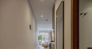 Ein modernes Interieur mit einem Flur, der zu einem Balkon mit Blick auf die Stadt führt.