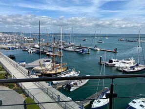 A marina with boats docked, a pier, and a clear sky. - Spinnaker Apartment 3 bed Waterside Apartment (Cowes)